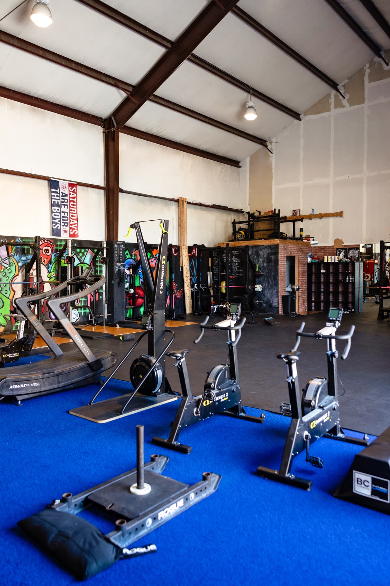 The training floor at The Pack with turf, bikes, sled and squat racks